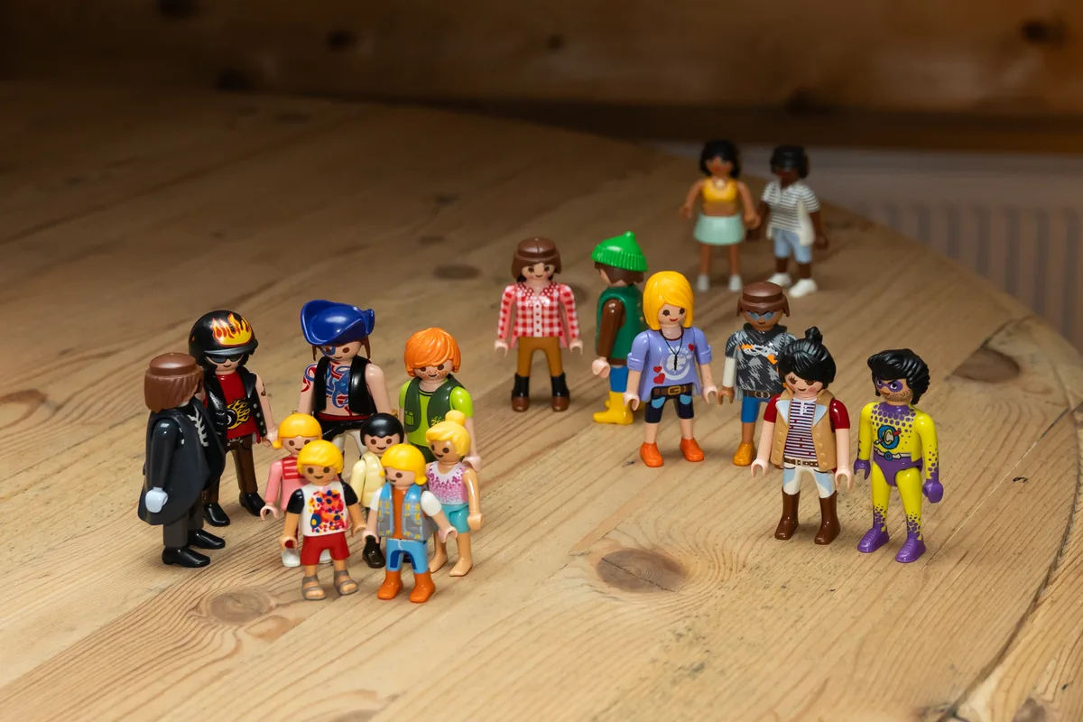 Kleurrijke speelgoedfiguren in groepjes op de houten tafel