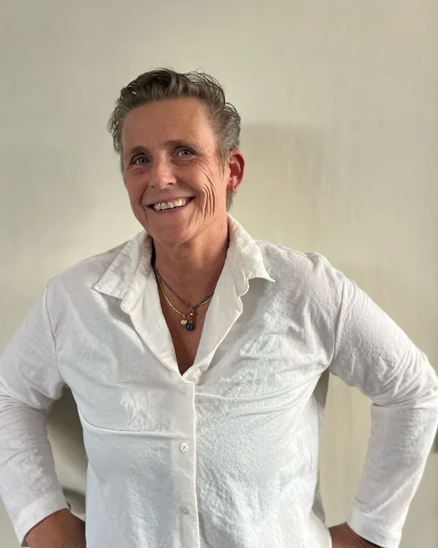 Portret van Colette Jalving, lachend in een witte blouse
