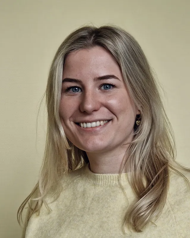 Portret van Emma, lachend in een lichtgele trui