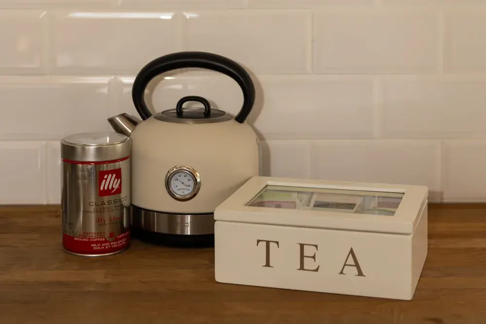 Waterkoker, koffieblik en theedoos op het aanrecht
