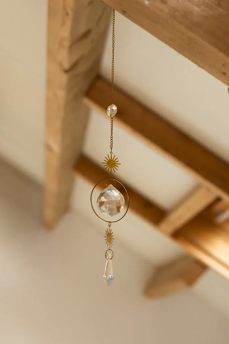 Kristallen suncatcher aan een houten balk